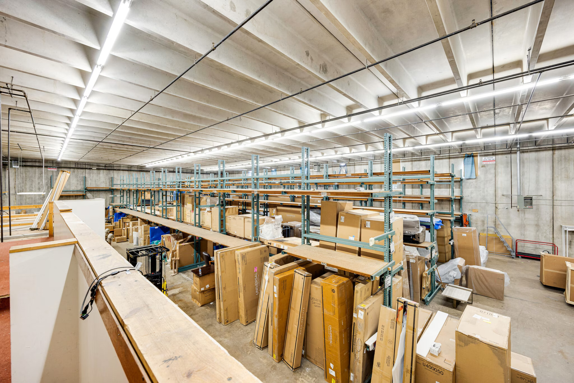 Storage area viewed from the mezzanine rail, with racking rows below.